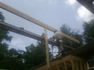 Carpenter setting a ridge beam over a new addition frame — Ice Dam Removal by Roofing Brothers in Wataga