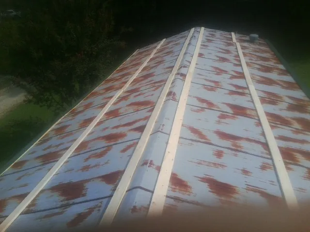Rusted metal roof panels with new wood purlins before replacement — Storm Damage Roof Repair in Wataga by Roofing Brothers
