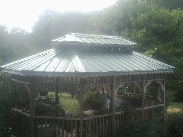 Two tier green metal roof on a garden gazebo in Wataga