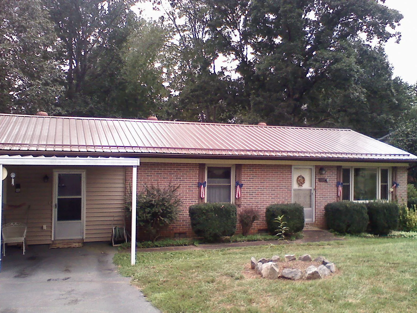 Bronze metal roof and carport on a brick ranch home — Roof Repair work by our crew in Wataga